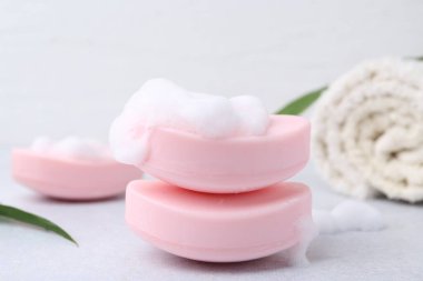 Beyaz masadaki köpüklü sabun çubukları, yakın plan.