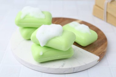 Beyaz masadaki köpüklü sabun çubukları, yakın plan.