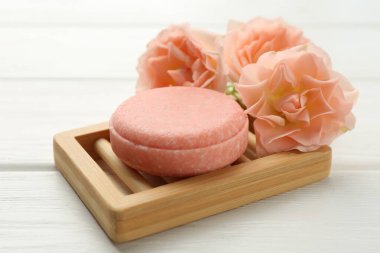 Sabun çubuğu ve beyaz ahşap masada güzel çiçekler, yakın plan.