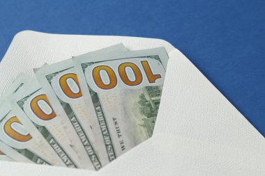 Para bonusu. Mavi arkaplanda dolar banknotları olan zarf, yakın plan