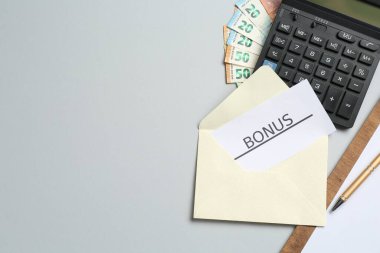 Bonus, para, pano ve hesap makineli kart açık gri arka planda, düz yatıyordu. Metin için boşluk