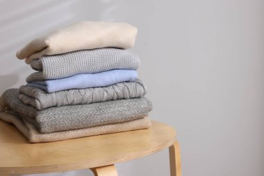 Yünlü süveter yığını ahşap masada, arka planda. Metin için boşluk