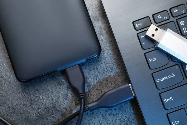 USB flaş bellek, sabit disk kablo ve laptop ile koyu gri masa, düz yatıyordu