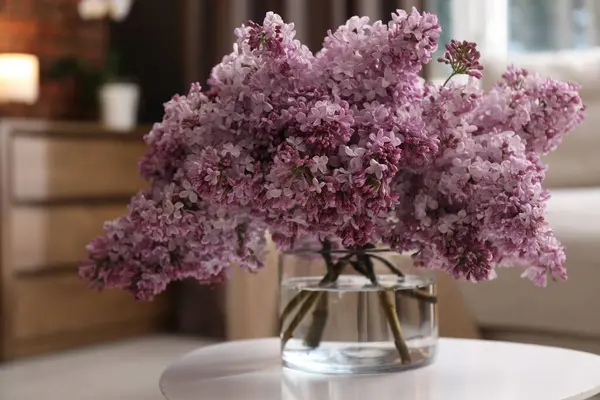 İçerideki masada vazoda güzel leylak çiçekleri.