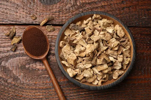 Kuru hindiba kökleri kase ve kaşık içinde, tahta masa üzerinde toz, düz yatıyordu.