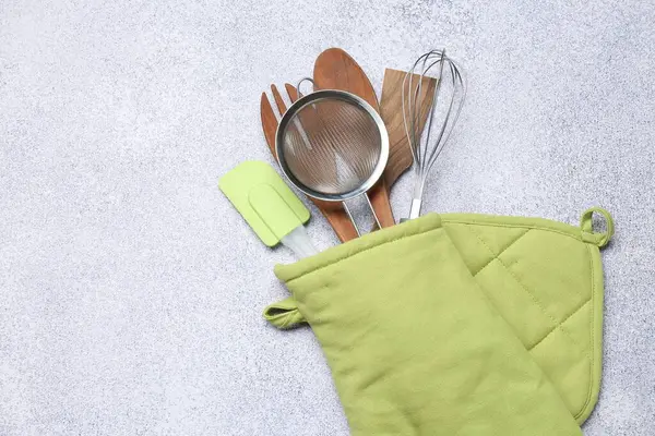 Farklı mutfak aletleri fırın eldivenlerinde, ışık masasında, üst tarafta. Metin için boşluk