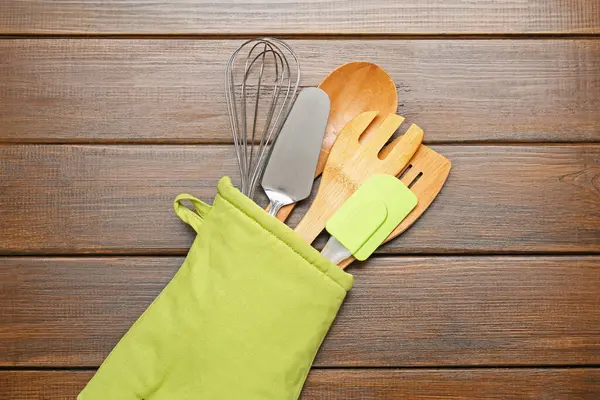 Farklı mutfak aletleri fırın eldiveni ahşap masa, üst görünüm