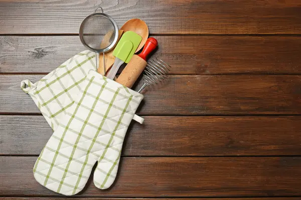 Ahşap masadaki fırın eldiveninde farklı mutfak aletleri, üst manzara. Metin için boşluk