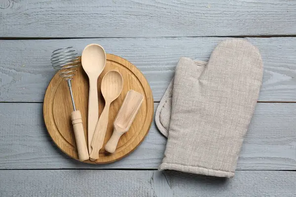 Farklı mutfak gereçleri ve fırın eldivenleri açık gri ahşap masa, düz yatıyordu.