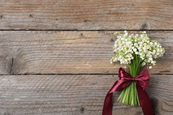 Ahşap arka planda bir buket güzel vadi zambağı, üst manzara. Metin için boşluk