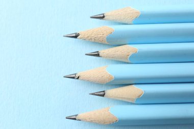 Açık mavi arkaplanlı çizgili kalemler, yukarıda. Metin için boşluk