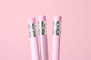 Pembe arka planda silgi olan grafit kalemler, yakın plan.