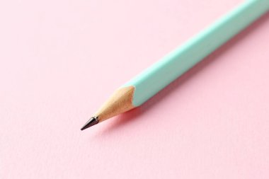 Pembe arka planda bir grafit kalem, yakın plan.