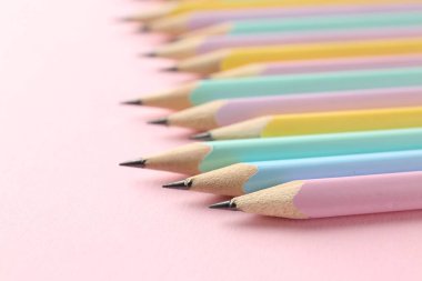 Pembe arka planda birçok grafit kalem, yakın plan. Metin için boşluk