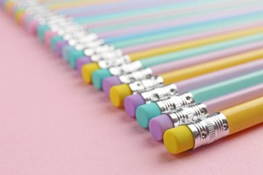 Pembe arka planda silgileri olan grafit kalemler, yakın plan. Metin için boşluk