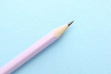 Açık mavi arkaplanda bir grafit kalem, üst görünüm