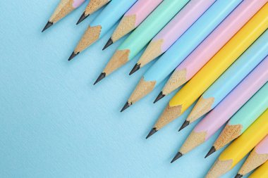 Açık mavi zemin üzerinde birçok grafit kalem, düz yatıyordu. Metin için boşluk