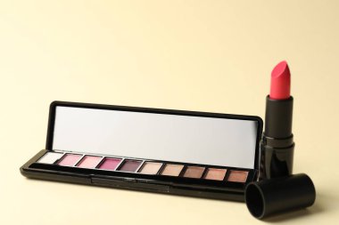 Bej arka planda aynalı ve rujlu göz falı, yakın plan.