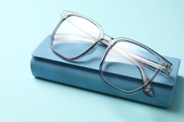 Açık mavi arka planda şık gözlüklü çanta, yakın plan