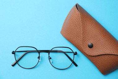 Açık mavi arka planda şık gözlüklü çanta, düz uzanma