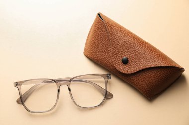 Bej arka planda şık gözlüklü çanta, düz yatış