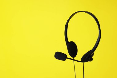 Sarı zemin üzerinde mikrofon olan kulaklık, metin için boşluk