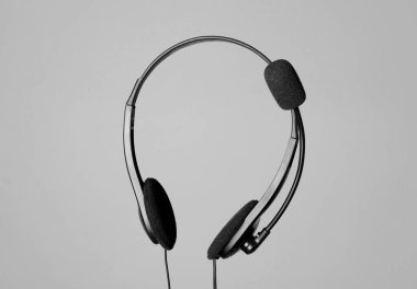 Açık gri arka planda mikrofonlu kulaklık.