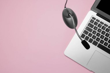 Profesyonel mikrofon ve pembe arka planda dizüstü bilgisayar. Metin için boşluk