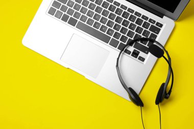 Sarı arka planda mikrofon ve dizüstü bilgisayarı olan kulaklık, üst görünüm