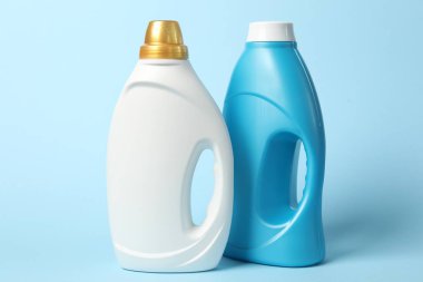 Açık mavi arkaplanda yumuşatıcı şişeler