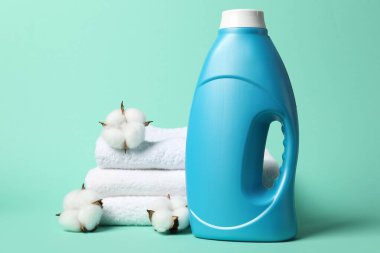 Kumaş yumuşatıcı, pamuk çiçekleri ve turkuaz arka planda havlular.