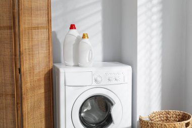 Çamaşır makinesinde yumuşatıcı şişeler.