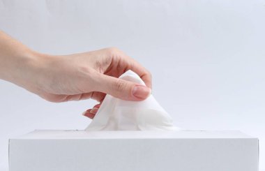 Beyaz arka planda mendili kutusundan çıkaran kadın, yakın plan.
