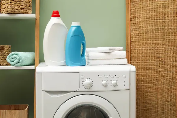 İçerideki çamaşır makinesinde yumuşatıcı ve havlu şişeleri.