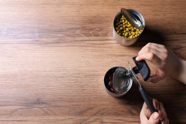 Kadın, tahta masada konserve açacağıyla fasulye konservesi açıyor. Metin için boşluk