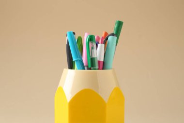 Kalemler ve kalemler bej arka planda, yakın plan