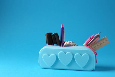 Açık mavi arka planda kalem kutusunda farklı bir kırtasiye malzemesi. Metin için boşluk