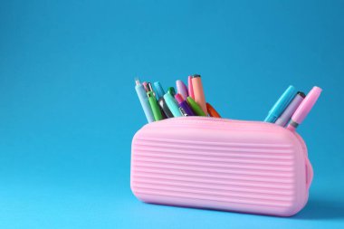 Açık mavi arka plandaki kalemler ve kalemler. Metin için boşluk