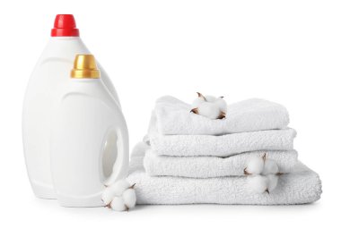 Kumaş yumuşatıcı şişeleri, yığılmış havlular ve beyaz üzerine izole edilmiş pamuk çiçekleri.
