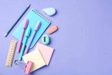 Menekşe arkaplan üzerine kalem ve diğer kırtasiye malzemesi, düz. Metin için boşluk