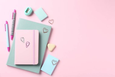 Kalemler ve pembe arka plandaki diğer kırtasiyeler, düz. Metin için boşluk