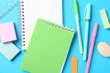 Açık mavi zemin üzerinde kalemler ve diğer kırtasiye düz yatıyordu