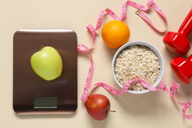 Elektronik mutfak ölçeği, mezura, bej masa üzerindeki dambıl ve ürünler, düz yatak. Diyet