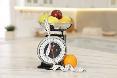 Meyveli mutfak pulları ve kapalı alandaki hafif mermer masada mezura.