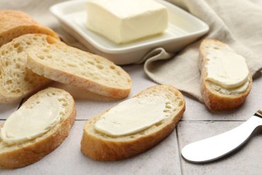 Üzerinde tereyağı ve bıçak bulunan ekmek parçaları, yakın plan.