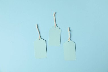 Açık mavi arkaplanda dizgileri olan boş etiketler, düz yatıyordu