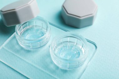 Açık turkuaz arka planda kontak lensleri, yakın plan