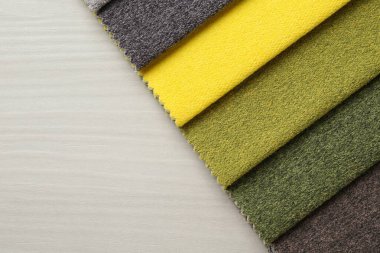 Açık ahşap masadaki farklı kumaşlardan örnekler, üst manzara. Metin için boşluk