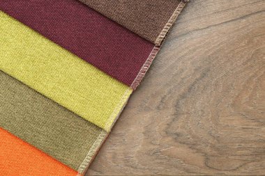 Tahta masadaki farklı kumaşlardan örnekler, üst manzara. Metin için boşluk