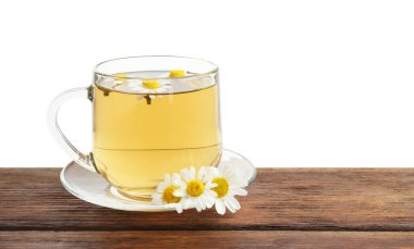 Cam fincanda nefis papatya çayı ve beyaz arka planda tahta masada taze çiçekler.